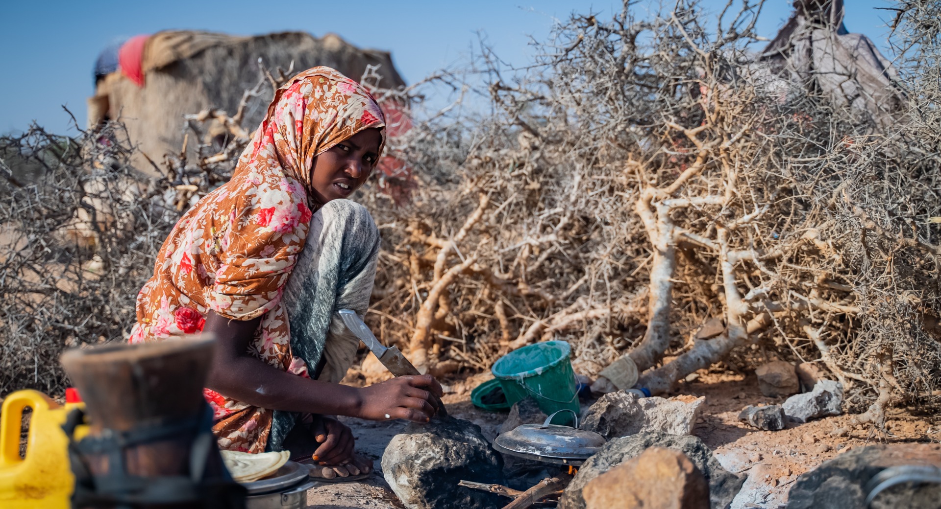 A girl, 16, makes breakfast for her family. Because of the drought and increase in food prices, nomadic communities like hers have struggled to survive.